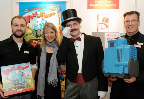 Alexander Jung (ganz links), Grafiker von „Voll in Fahrt“ freut sich freut sich über die Auszeichnung Graf Ludo 2011 in der Kategorie „Beste Kinderspielgrafik“ gemeinsam mit Graf Ludo und Andreas Finke vom Amigo Verlag. Foto: Graf Ludo